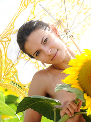 Suzanna A's carefree allure and charming beauty stands out amidst a field of sunflowers