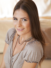 Csilla smiles sweetly as she strips off her clothes on top of the sofa